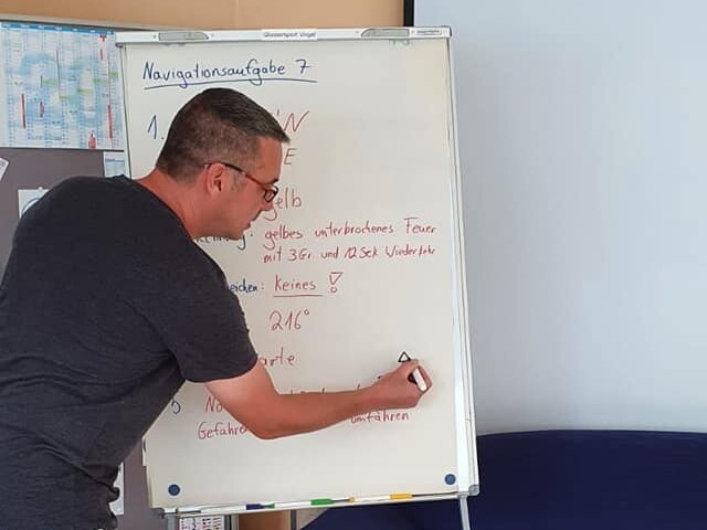 Peter Vogel präsentiert auf Flipchart die Navigatrionsaufgaben.
